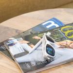 Auf einem runden Tisch liegen Zeitschriften und weiße Sonnenbrille.