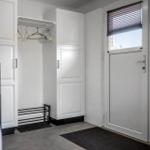Eingangsbereich mit Kleiderschrank, Tür und Stufen zur oberen Etage.