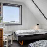 Schlafzimmer mit Dachschräge, Bett und Fenster mit Blick.