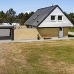 Moderne Villa mit Garage und Garten. Holzbank vor Eingang.