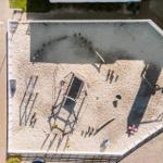 Großer Sandplatz mit Spielgeräten und Kinderspielzeug.