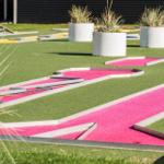 Minigolfplatz mit grünem Rasen und pinken Bahnen