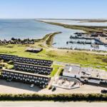Strandnahe Ferienanlage mit Bootshafen und mehreren Gebäuden.