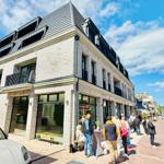 Moderne Villa mit Balkonen und Glasfassade an belebter Straße