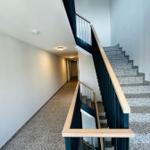 Treppe mit Steinstufen und Holzgeländer führt zur oberen Etage.