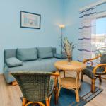 Living room with sofa, two chairs and table. Access to terrace.