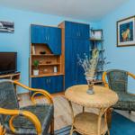 A living room with blue walls, a round table, and two chairs.