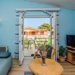 Living room with terrace, sofa, TV, and round table.