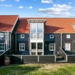 Moderne Ferienwohnung mit rotem Dach und Balkonen im Freien.