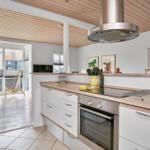 Küche mit Holzoberflächen und Blick auf Balkon mit Hängesessel.