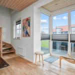 Raum mit Holztreppe, großem Fenster und Sitzgelegenheit