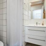 Badezimmer mit Toilette, Duschvorhang und Waschbecken mit Spiegel.