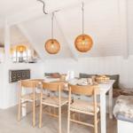 Essbereich mit Tisch, Stühlen und Sitzbank unter weißem Dach.