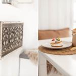 Wanddekoration mit Holzschnitt und Tisch mit Kuchen und Tasse.