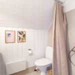 Badezimmer mit Dusche, Toilette und Waschbecken. Wandverkleidung und Bilder sichtbar.