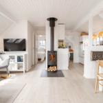 Wohnbereich mit Kamin, Küche und Schlafzimmer im Dachgeschoss.