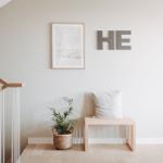 Eingangsbereich mit Stuhl, Kissen, Pflanze und Wanddekoration.