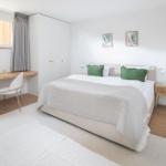 Schlafzimmer mit Bett, Schreibtisch und Kleiderschrank