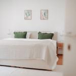 Schlafzimmer mit Bett, zwei Nachttischen und Wandbildern.