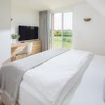 Schlafzimmer mit Doppelbett, Fernseher und Terrassentür.