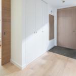 Eingangsbereich mit Schuhschrank, Tür und Blick in Wohnzimmer.