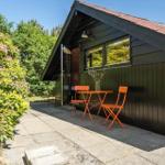Ein kleines Haus mit einer Terrasse und orangefarbenem Tisch und Stühlen.