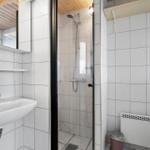Badezimmer mit Dusche, Waschbecken und Toilette.
