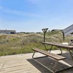 Holzterrasse mit Picknicktisch und Blick auf Dünen