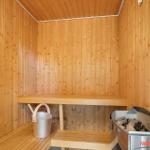 Sauna mit Holzwand, Sitzbank und Harvia Heizung.