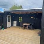 Terrasse mit Tisch, Stühlen und Beleuchtung unter Dach
