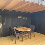 Terrasse mit Holztisch und Stühlen unter Dach