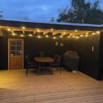 Terrasse mit Tisch, Stühlen und Grill unter Lichterkette
