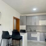 Küche mit Arbeitsplatte und schwarzen Barhockern