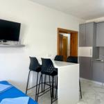 Küche mit Essbereich, TV und Bett im Vordergrund.