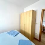 Schlafzimmer mit Bett, Kleiderkammer und Tür zum Flur.