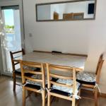 Esstisch mit vier Stühlen und Spiegel an der Wand.