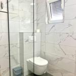 Badezimmer mit Dusche, Toilette und Fenster