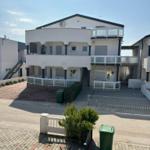 Modernes Mehrfamilienhaus mit Balkonen und gepflastertem Hof