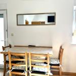 Esstisch mit vier Stühlen und Spiegel an der Wand.