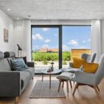 Wohnzimmer mit Sofa, Sesseln und Blick auf Garten