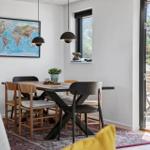 Esszimmer mit Tisch, Stühlen und Weltkarte an der Wand. Durchgang zur Terrasse.