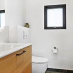 Badezimmer mit Waschbecken, Toilette und Fenster.