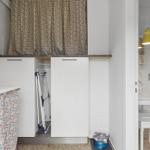 Small bathroom with sink and blue stool. Behind the mirror is a door.