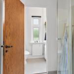 Bathroom with shower, toilet, and window.