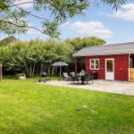 Red garden house with terrace, grill, and croquet lawn.