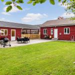 Red wooden house complex with terrace, grill, and lawn areas.