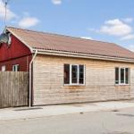 A house with wooden siding and a red gable roof. Windows and antenna are visible.