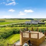 Terrasse mit Sitzgelegenheit und Blick auf grüne Landschaft.