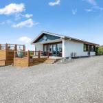 Moderne Villa mit Terrasse und Kiesweg. Hausnummer 13 sichtbar.