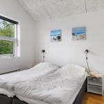 Schlafzimmer mit Doppelbett, Fenster und zwei Wandbildern